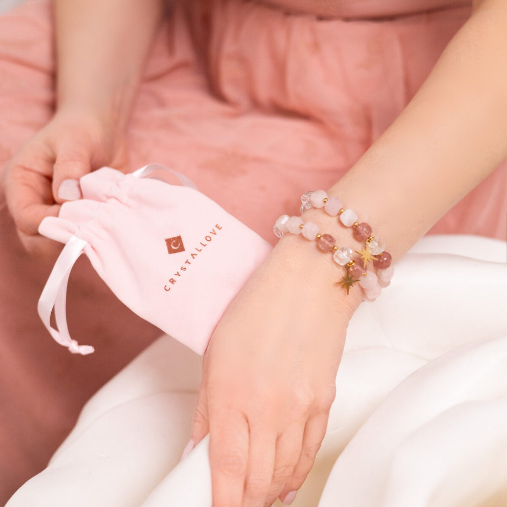 Zestaw prezentowy Crystallove: różowa płytka Gua Sha z kwarcu oraz bransoletka z kamieni naturalnych na eleganckim tle.