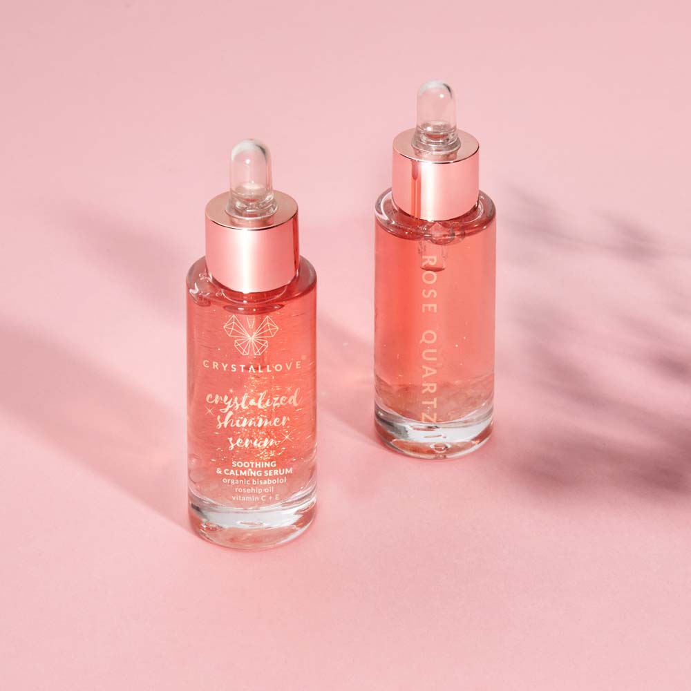 Serum do twarzy z kwarcem różowym CRYSTALLOVE w szklanej butelce na jasnym tle
